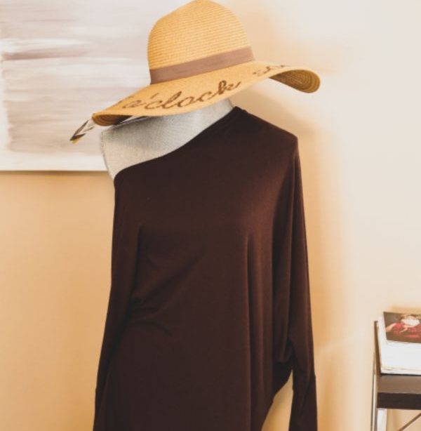 Dress form wearing a dark loose top and a straw hat